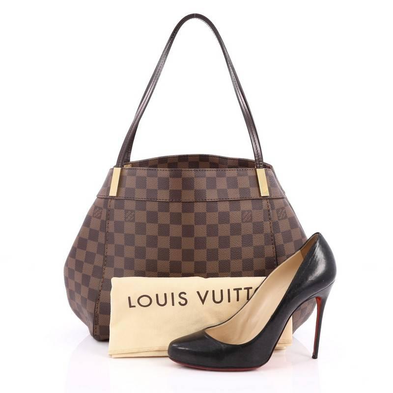 This authentic Louis Vuitton Marylebone Handbag Damier PM mixes classic style with modern functionality. Crafted from damier ebene coated canvas, this elegant tote features dual flat handles, gold-tone bar accents, gusseted sides with snap closures,