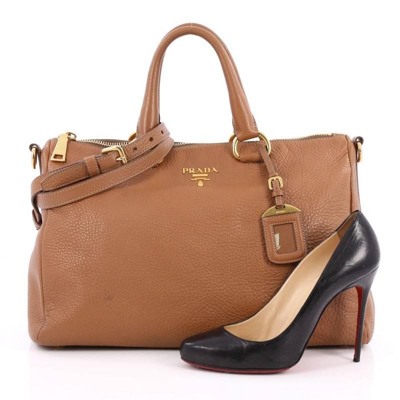This authentic Prada Convertible Boston Bag Vitello Daino Medium is the perfect bag to complete any outfit. Crafted from brown vitello daino leather, this bag features dual-rolled leather handles, detachable shoulder strap, raised Prada logo,
