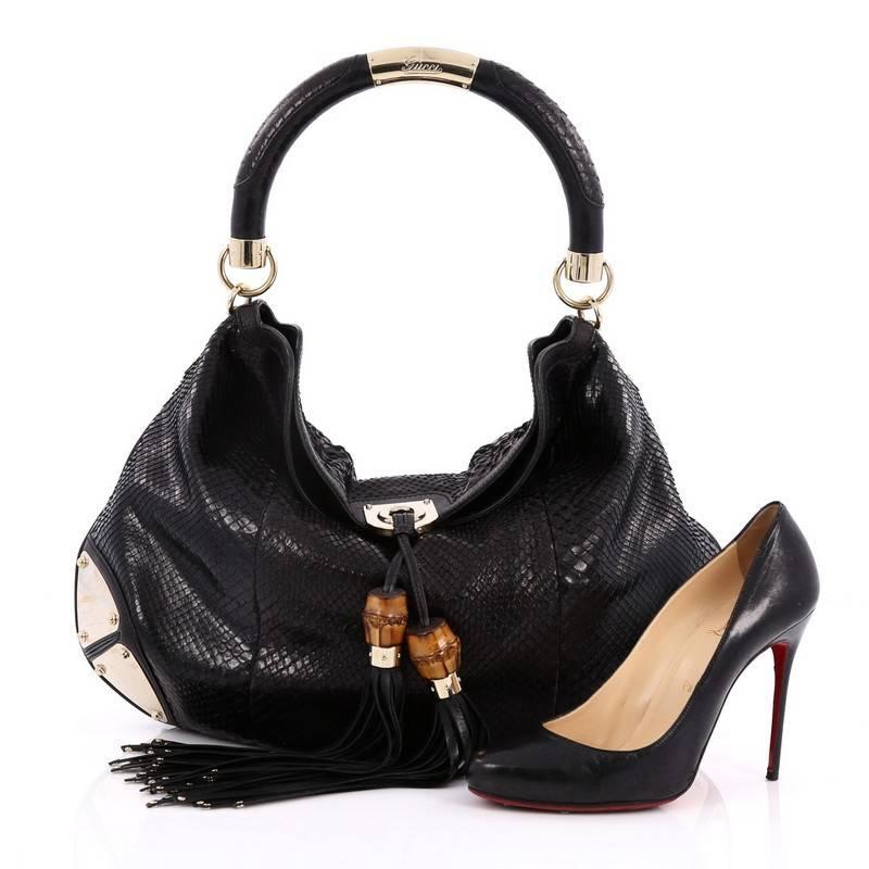 This authentic Gucci Indy Hobo Python Large showcases the brand's classic design with luxurious detailing adding an exotic chic twist. Crafted from genuine black python skin, this eye-catching hobo features bamboo and fringe tassels, looped handle,
