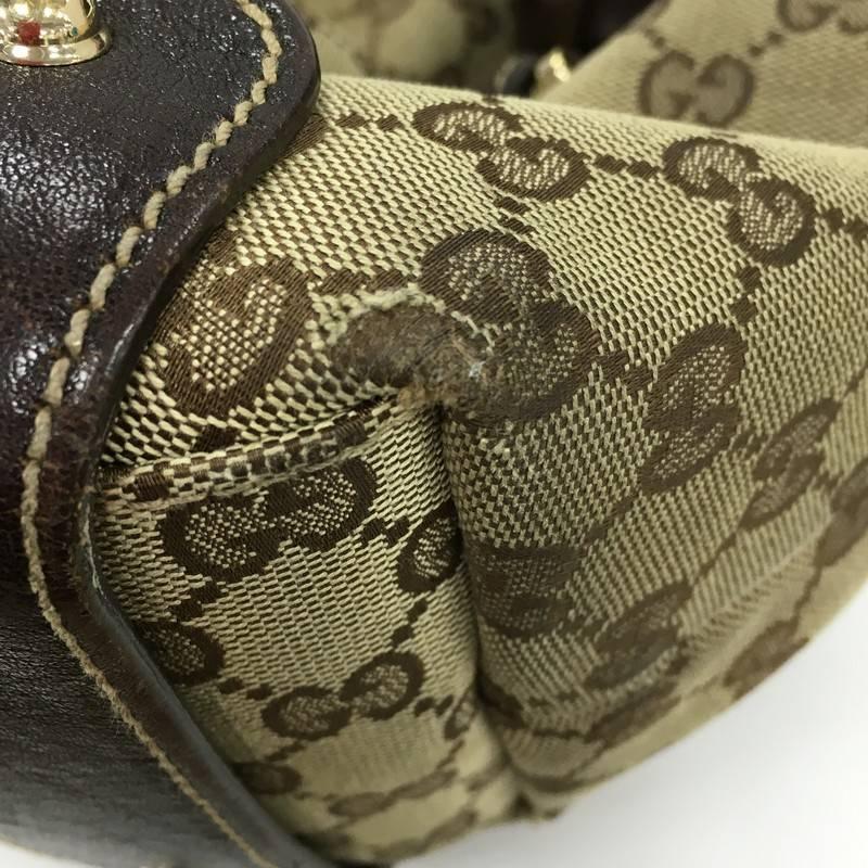 This authentic Gucci Pelham Shoulder Bag GG Canvas Medium is a stylish bag perfect for everyday use. Crafted in brown GG monogram canvas and dark brown leather trims, this shoulder bag features braided leather straps, signature horsebit detailing,