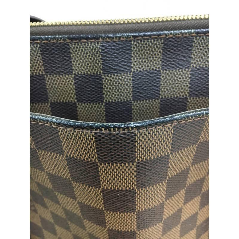 This authentic Louis Vuitton Belem Handbag Damier MM is a unique, functional everyday piece for any Louis Vuitton lover. Crafted from the brand's popular damier ebene coated canvas, this tote features dual flat brown leather handles, brown leather