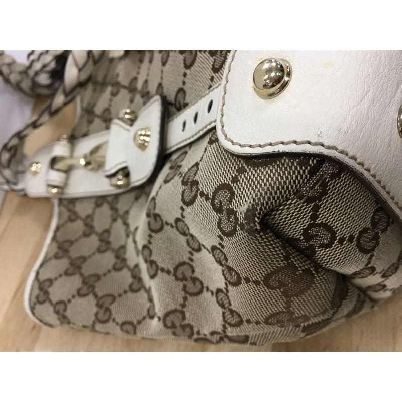 This authentic Gucci Pelham Shoulder Bag GG Canvas Small is a stylish bag perfect for everyday use. Crafted in brown GG monogram canvas and white leather trims, this shoulder bag features braided leather straps, signature horsebit detailing,