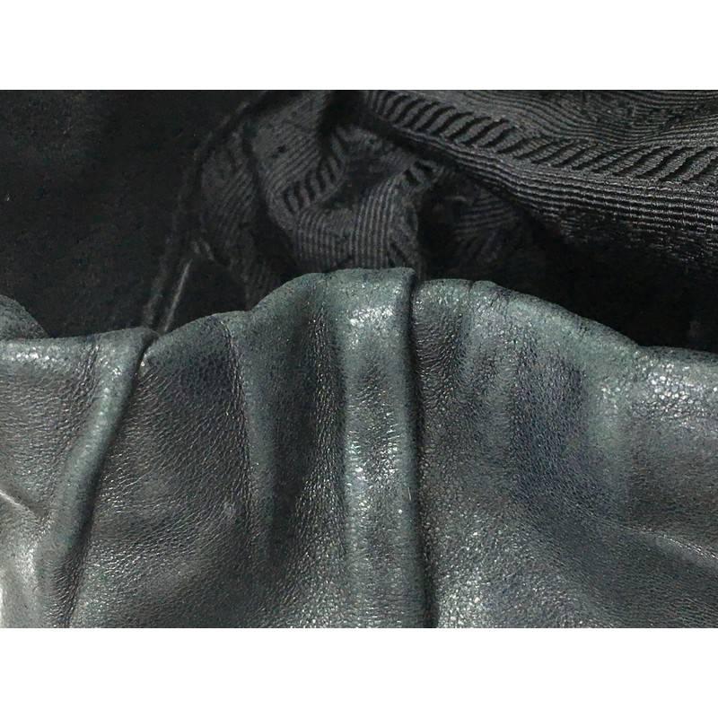 This authentic Prada Gaufre Side Pocket Hobo Nappa Leather Large is a stylish and easy-to-carry bag. Crafted from black ruched nappa leather, this hobo features a rolled leather handle, two exterior side flat pockets, protective base studs, Prada