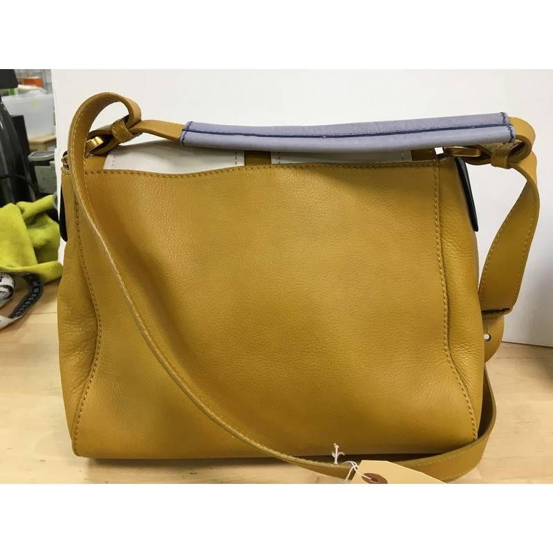 This authentic Fendi Anna Flap Bag Leather showcases a classic style with a 70's flair. Crafted from color-blocked white and mustard yellow leather panels, this stylish bag features leather top handle, an adjustable strap, protective base studs,