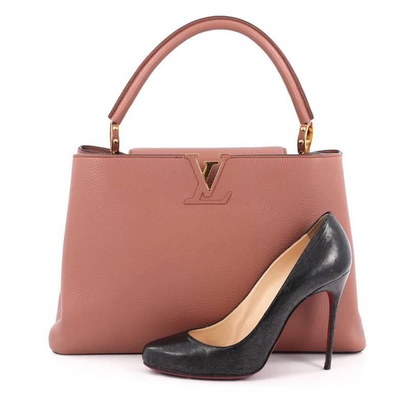 This authentic Louis Vuitton Capucines Handbag Leather MM is sophisticated and ladylike luxurious bag from the brand's Fall 2013 Collection inspired by its Parisian heritage. Crafted from dusty pink taurillion leather, this chic, stand-out bag