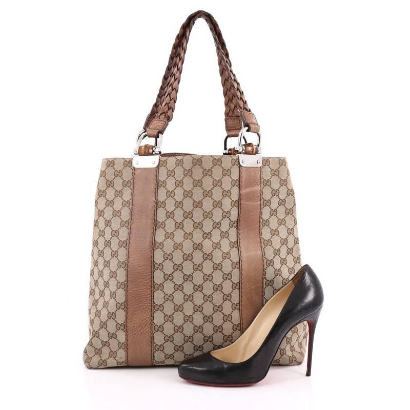 This authentic Gucci Bamboo Bar Tote GG Canvas Large is a simple yet sophisticated daily bag for the on-the-go woman. Crafted from brown GG canvas, this beautiful and functional tote features braided dual strap handles with bamboo details and