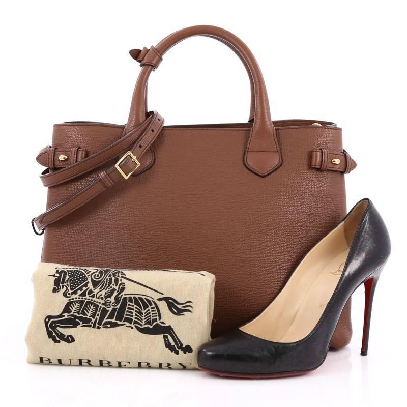 This authentic Burberry Banner Convertible Tote Leather and House Check Canvas Medium is sophisticated and luxurious in design ideal for everyday use. Crafted in brown leather, this tote features dual-rolled handles, detachable strap, gold stamped