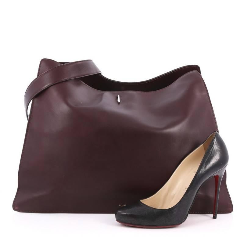 This authentic Celine New Shoulder Bag Smooth Calfskin Large presented in the brand's Fall/Winter 2012 Collection is an elegant, minimalist bag made for any casual or sophisticated outfit. Crafted with burgundy smooth calfskin, accented with