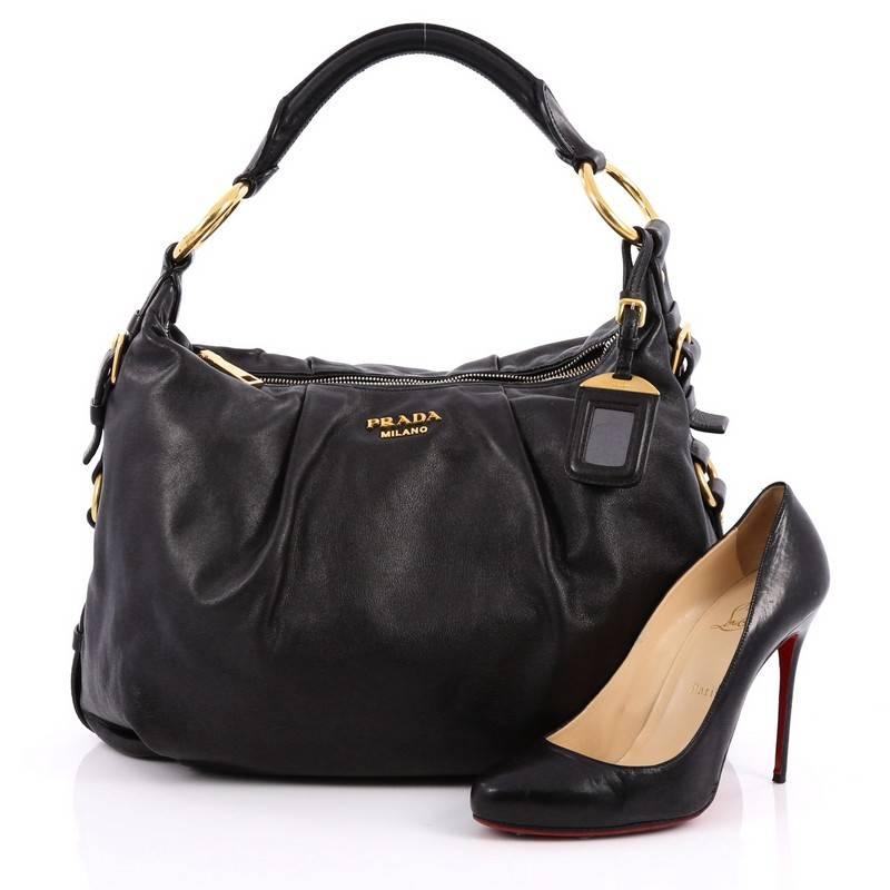 This authentic Prada Pleated Hobo Soft Calfskin Medium is ideal for everyday use. Crafted in black soft calfskin leather, this pleated bag features a rolled leather shoulder strap, raised Prada logo and gold-tone hardware accents. Its magnetic snap