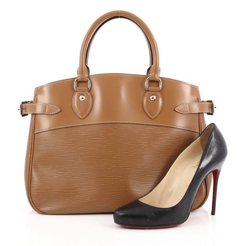 This authentic Louis Vuitton Passy Handbag Epi Leather PM is an understated yet elegant bag with a sophisticated look. Crafted from Louis Vuitton's signature epi leather in brown, this bag features silver-tone hardware accents, side belt strap