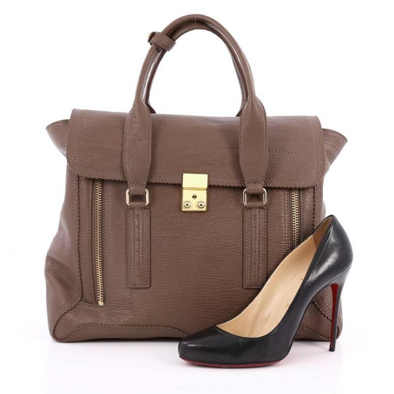 This authentic 3.1 Phillip Lim Pashli Satchel Leather Large is a practical bag with a stylish edge made for on-the-go moments. Crafted from light brown leather, this chic satchel features dual top handles, expandable zip sides, top flap push-lock