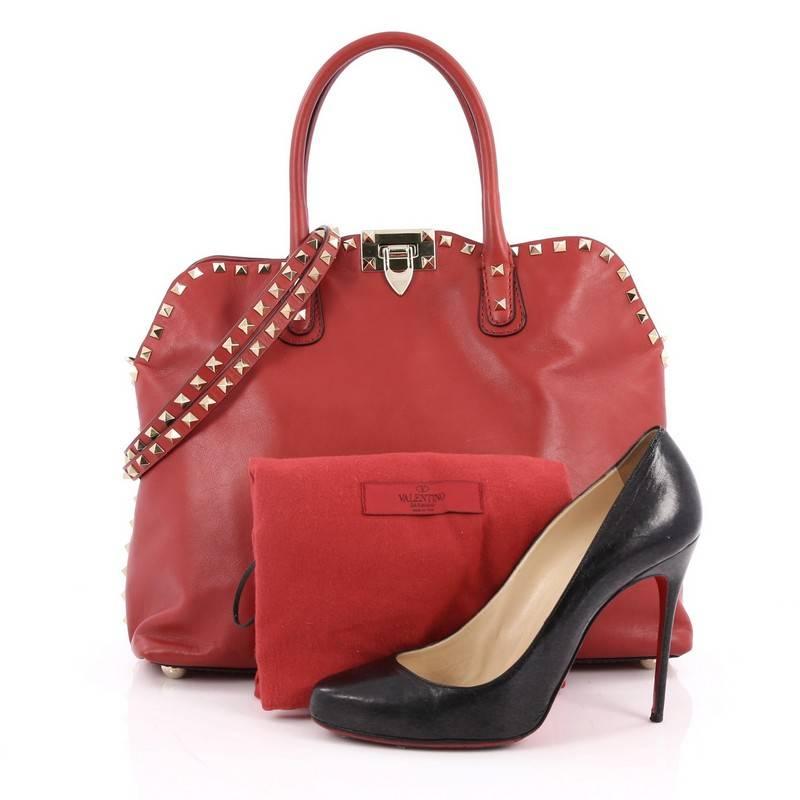 This authentic Valentino Rockstud Convertible Dome Satchel Leather is the perfect daily bag for the on-the-go fashionista. Crafted from red smooth leather, this stylish tote features dual-rolled top handles, gold-tone pyramid stud trim details,