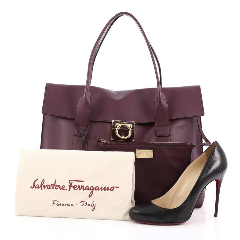 This authentic Salvatore Ferragamo Gancini Lock Flap Tote Leather Large is great for an everyday classy look. Crafted from purple leather, this bag features dual top rolled handles, gold Gancini flip-lock closure, protective base studs and gold-tone