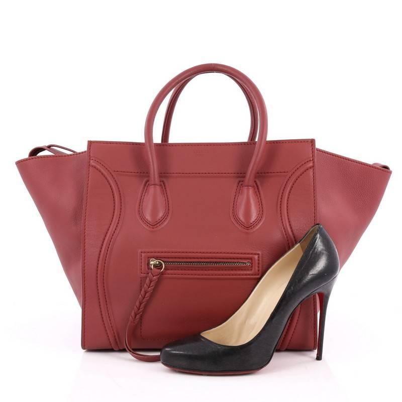 This authentic Celine Phantom Handbag Grainy Leather Medium is one of the most sought-after bags beloved by fashionistas. Crafted from red grainy leather, this minimalist tote features dual-rolled handles, an exterior front pocket, protective base