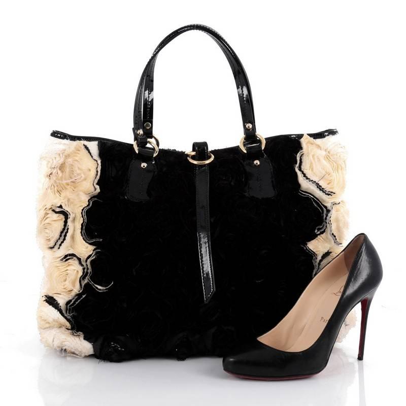 This authentic Valentino Rosier Tote Silk Medium is a glamorous and fun bag that will surely turn heads. Crafted from black and off-white silk organza flowers with black patent leather trims, this stylish tote features dual flat patent leather