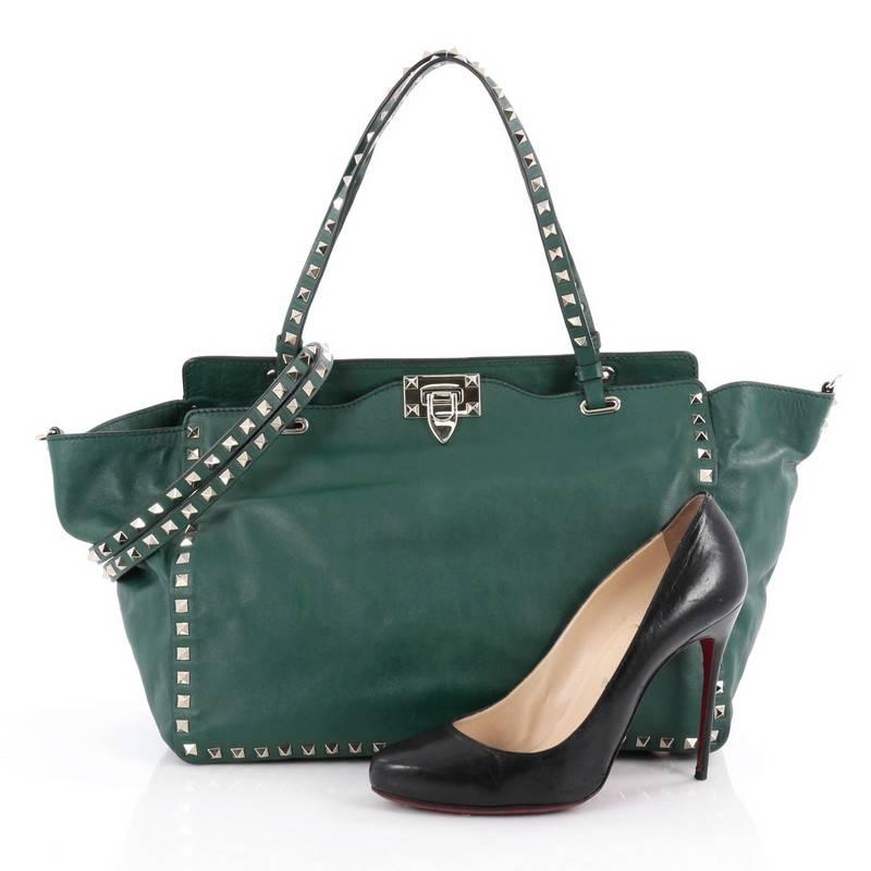 This authentic Valentino Rockstud Tote Soft Leather Medium mixes edgy style with luxurious detailing. Crafted from green soft leather, this stylish tote features dual tall flat handles, gold-tone pyramid stud trim details, signature clasp fastening,