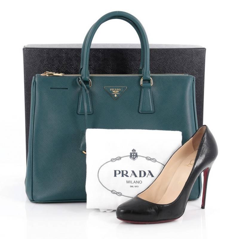 This authentic Prada Double Zip Lux Tote Saffiano Leather Large is the perfect bag to complete any outfit. Crafted from teal saffiano leather, this boxy tote features side snap buttons, raised Prada logo, dual-rolled leather handles and gold-tone