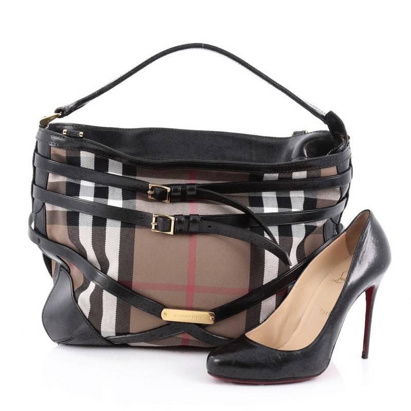 This authentic Burberry Bridle Dutton Hobo House Check and Leather is a marvelous hobo, ideal for everyday use. Crafted from Burberry house check canvas, this stylish bag features looping top handle, flat leather detachable long shoulder strap,