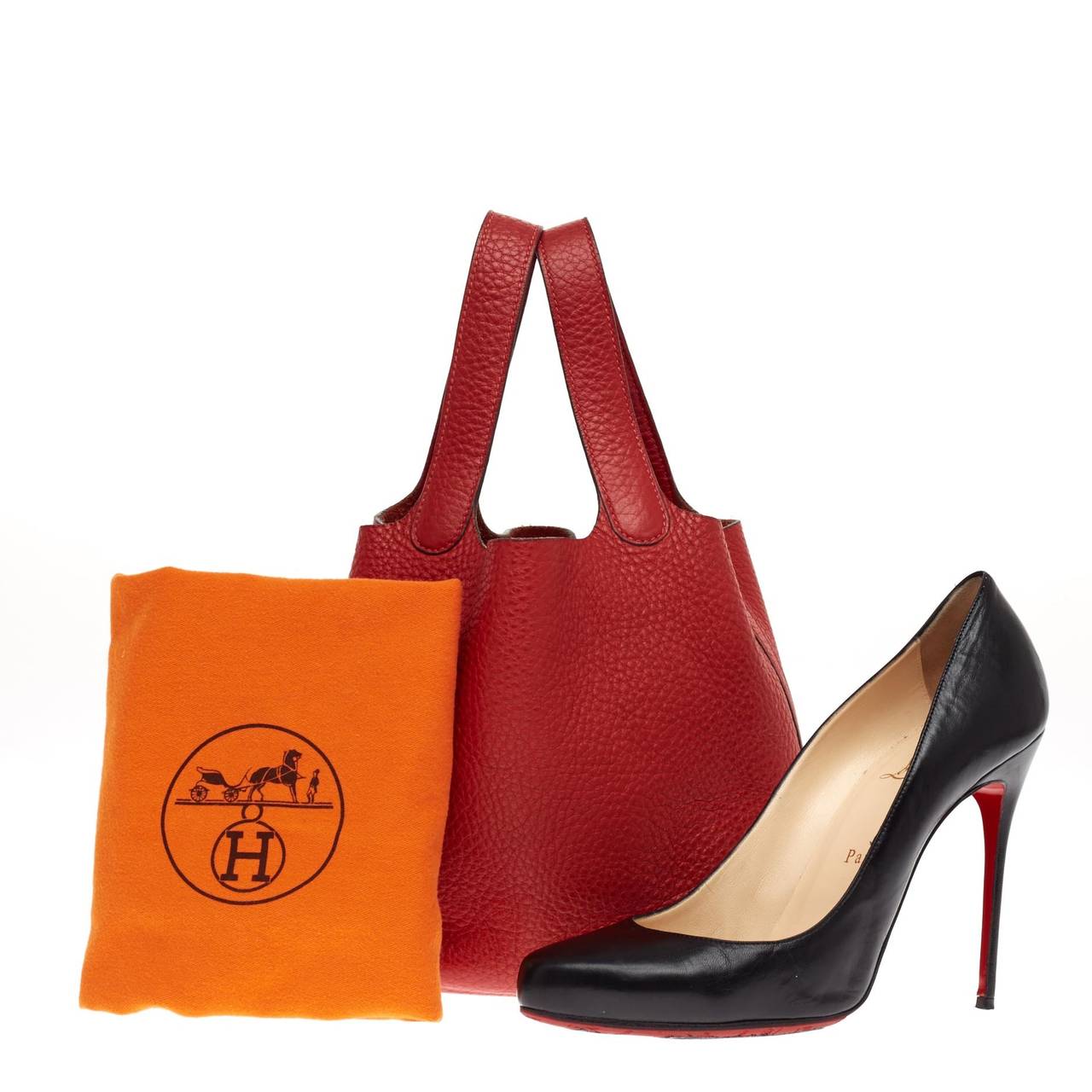This petite authentic Hermes Picotin Clemence in size PM in stunning Rouge Vif red is as functional as it is stylish. Accented with polished palladium hardware, this beautiful handle bag features a unique one-piece closing design with a clip and