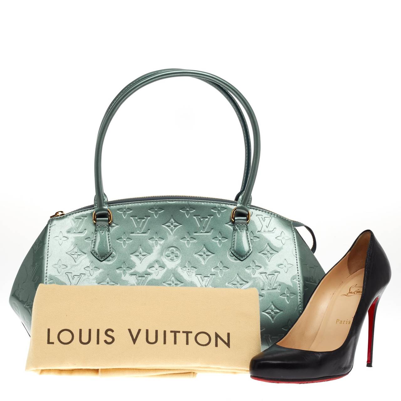 This authentic Louis Vuitton Sherwood Monogram Vernis in size GM comes in a lovely Givre blue shade accented with gold tone hardware. Constructed of sturdy Vernis leather, this dome bag features long dual-rolled leather handles that is perfect for