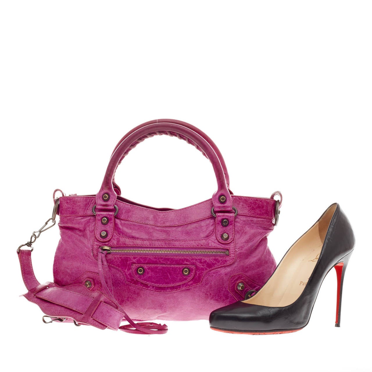 This authentic Balenciaga First Classic Studs in fuchsia purple is the perfect eye-catching accessory for spring. Constructed in soft, distressed leather, this easy-to-carry, everyday bag features Balenciaga's classic brass studs, whip stitched top