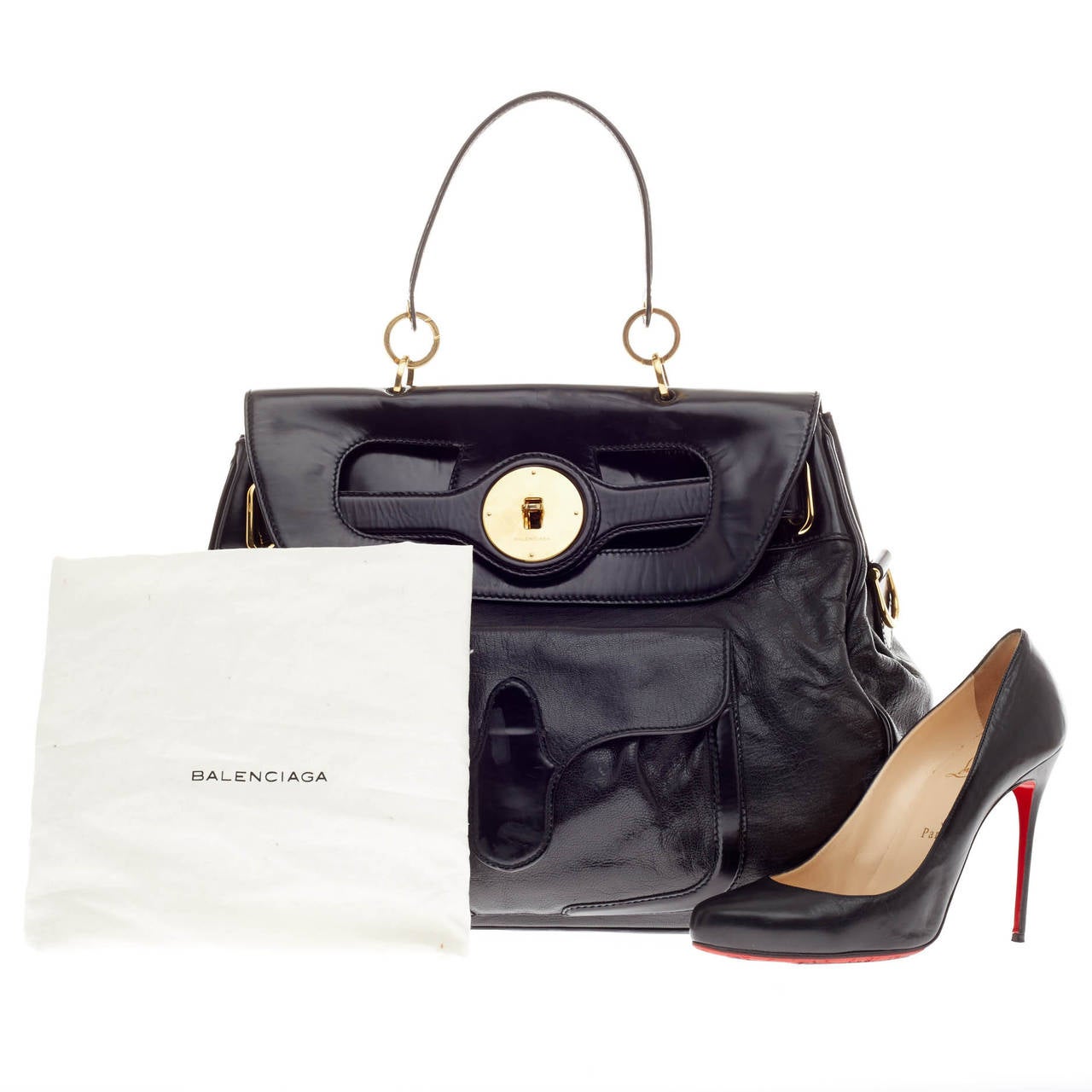 This authentic Balenciaga Lune Leather is a glamorous statement-making bag that complements both casual and sophisticated looks. Crafted from smooth black leather with patent leather accents, this bag features gold-tone hardware, twist-lock closure