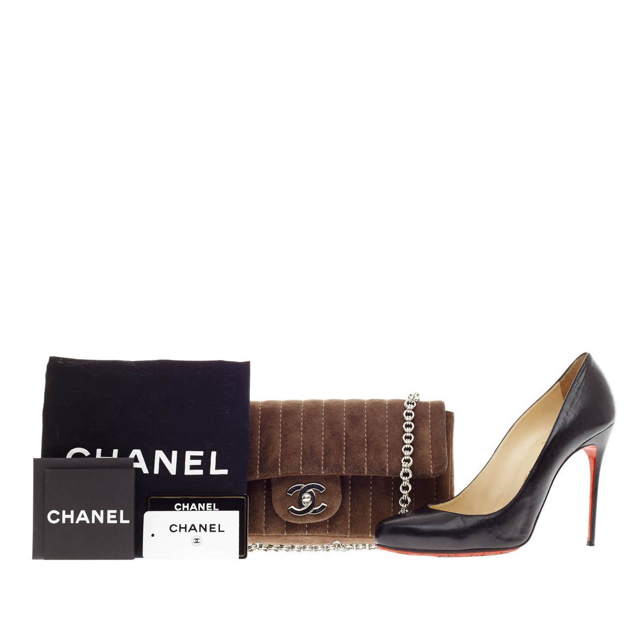 This authentic Chanel Mademoiselle Vertical Suede in size Small is a luxurious accessory made for casual and evening looks. Crafted from smooth brown suede with light brown vertical contrast stitching, this flap bag features polished silver-tone