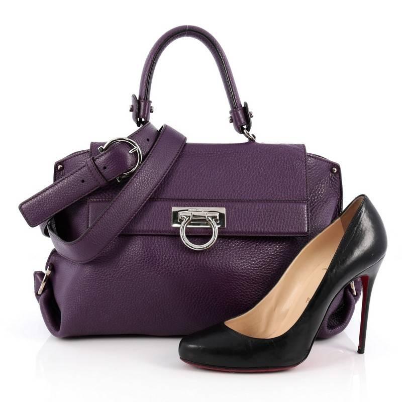 This authentic Salvatore Ferragamo Sofia Satchel Pebbled Leather Medium is a stylish and functional, chic bag perfect for the modern woman. Crafted in purple grainy leather, this bag features rolled leather handle, protective base studs, exterior