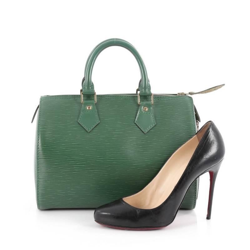 This authentic Louis Vuitton Speedy Handbag Epi Leather 25 is a timeless favorite of many. Crafted in borneo green epi leather, this bag features dual-rolled handles, subtle stamped LV logo, exterior side slip pocket and gold-tone hardware accents.