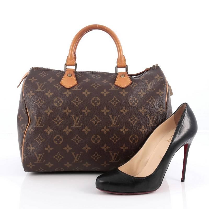 This authentic Louis Vuitton Speedy Handbag Monogram Canvas 30 is spacious and light, making it ideal to use everyday. Constructed in Louis Vuitton's classic brown monogram coated canvas, this iconic Speedy features dual-rolled leather handle,