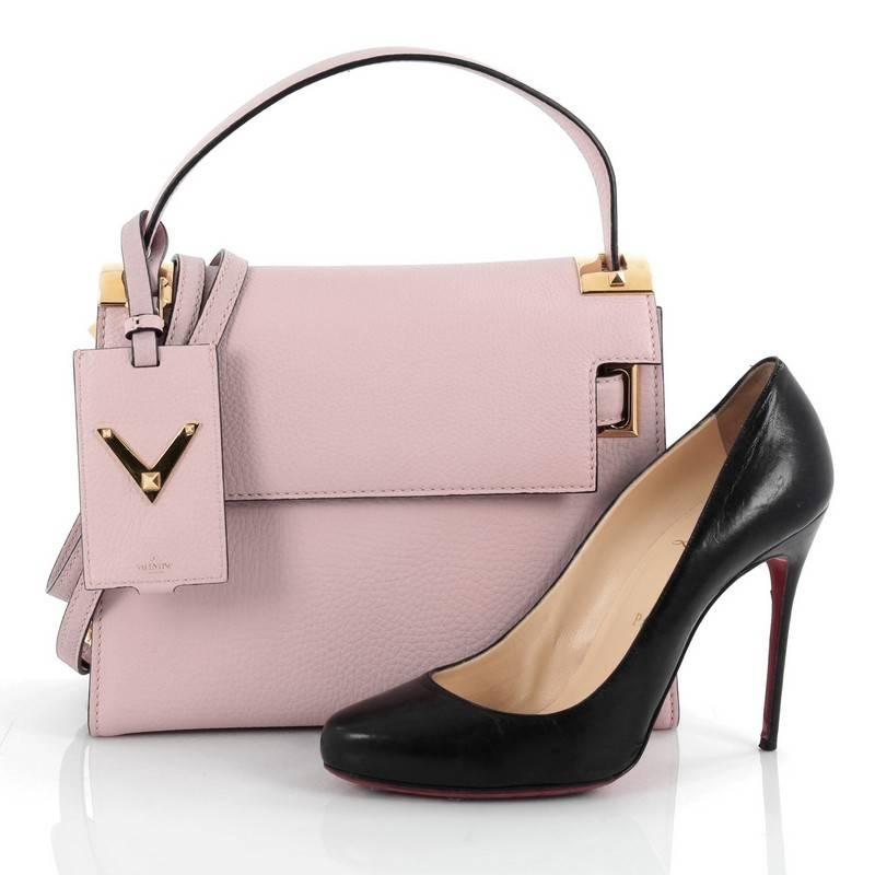 This authentic Valentino My Rockstud Convertible Satchel Leather Small displays a chic design perfect for the stylish fashionistas. Crafted in mauve pink leather, this bag features single loop leather handle, protective base studs and gold-tone