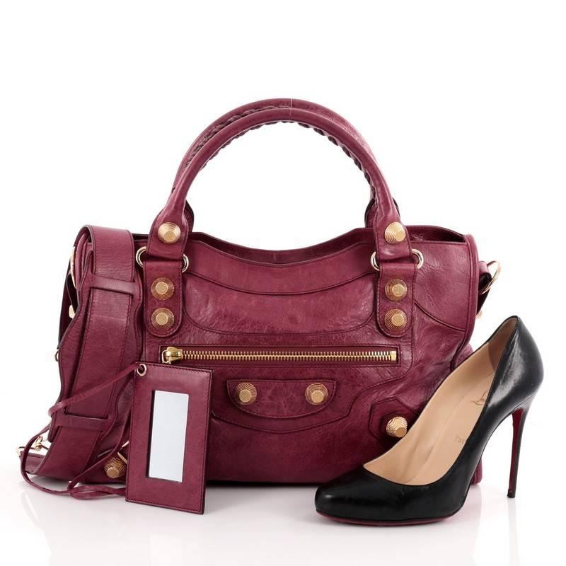 This authentic Balenciaga City Giant Studs Handbag Leather Medium is for the on-the-go fashionista. Constructed from berry purple leather, this popular bag features dual braided woven tall handles, exterior front zip pocket, iconic Balenciaga giant