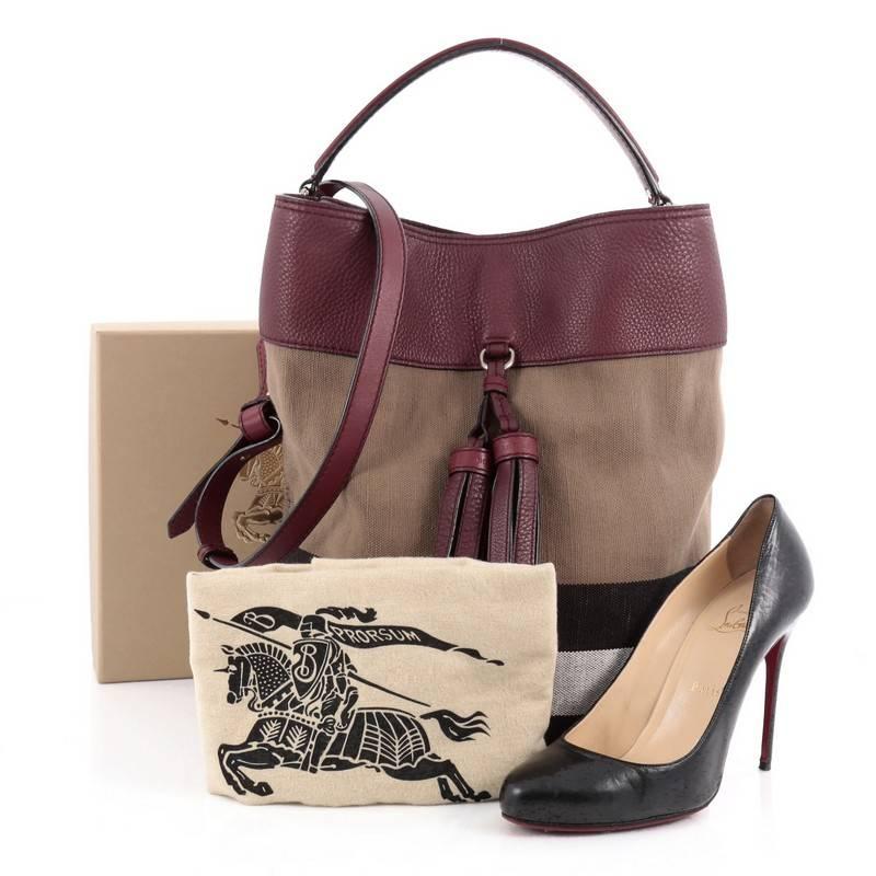 This authentic Burberry Susanna Tassel Hobo House Check Canvas Medium is ideal for on-the-go fashionista. Crafted in Burberry house check canvas, this hobo features maroon leather trims, leather tassel details, adjustable leather strap, protective