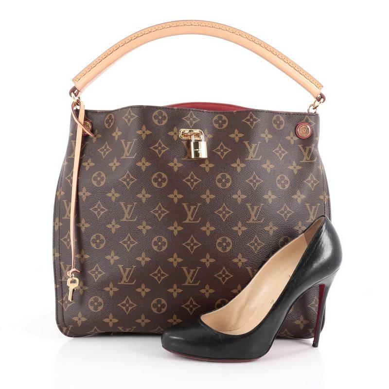 This authentic Louis Vuitton Gaia Handbag Monogram Canvas named after the Greek goddess, mixes elegant style with a feminine flair. Crafted from brown monogram coated canvas with red leather side gussets, this sophisticated bag features natural