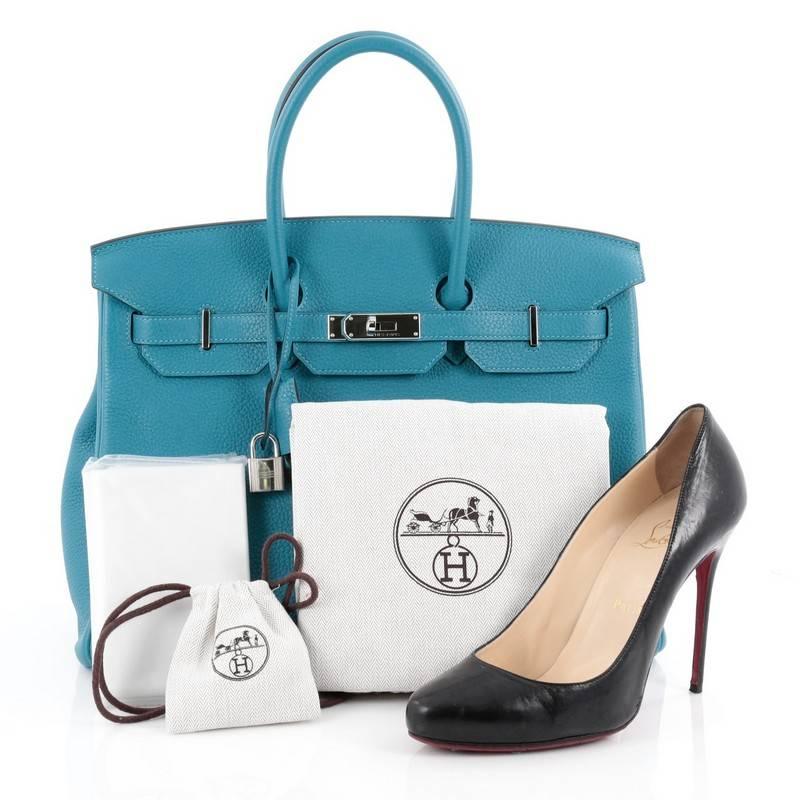 This authentic Hermes Birkin Handbag Turquoise Togo with Palladium Hardware 35 stands as one of the most-coveted bags. Constructed from scratch-resistant, iconic blue leather, this stand-out tote features dual-rolled top handles, frontal flap,