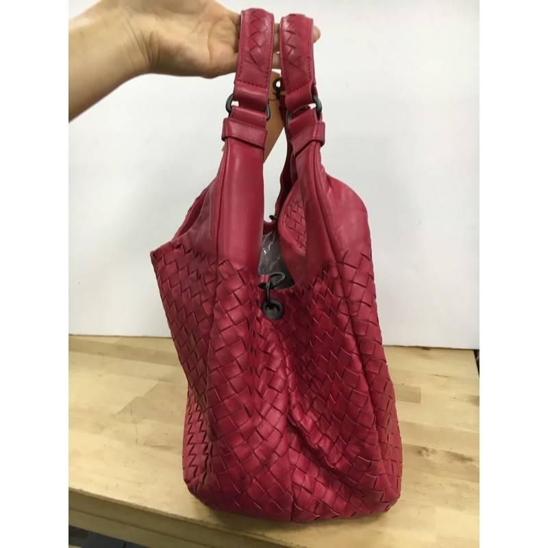 This authentic Bottega Veneta Intrecciato Nappa Small is both understated yet elegant perfect for the modern woman. Crafted from dark pink nappa leather in Bottega Veneta's signature intrecciato method, this functional shoulder bag features dual