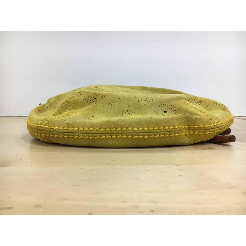 This authentic Louis Vuitton Onatah Hobo Suede PM is a stylish and functional must-have for LV lovers. Crafted from the brand's yellow suede, this hobo features a subtle perforated monogram design, adjustable leather shoulder strap, and aged