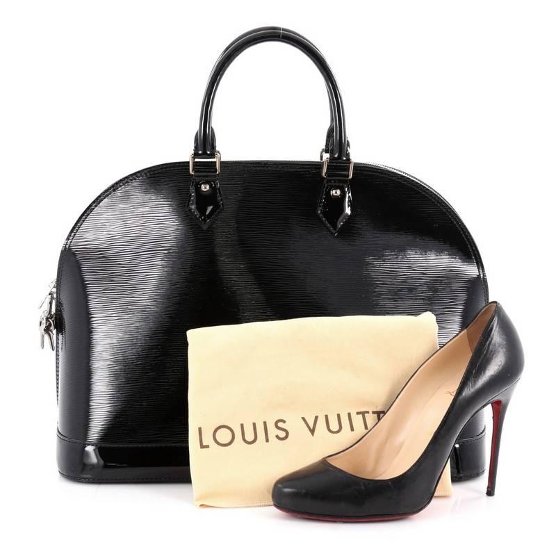 This authentic Louis Vuitton Alma Handbag Electric Epi Leather MM is elegant and as classic as they come. Constructed with Louis Vuitton's signature noir black electric epi leather, this bag features a structured and dome-like silhouette,