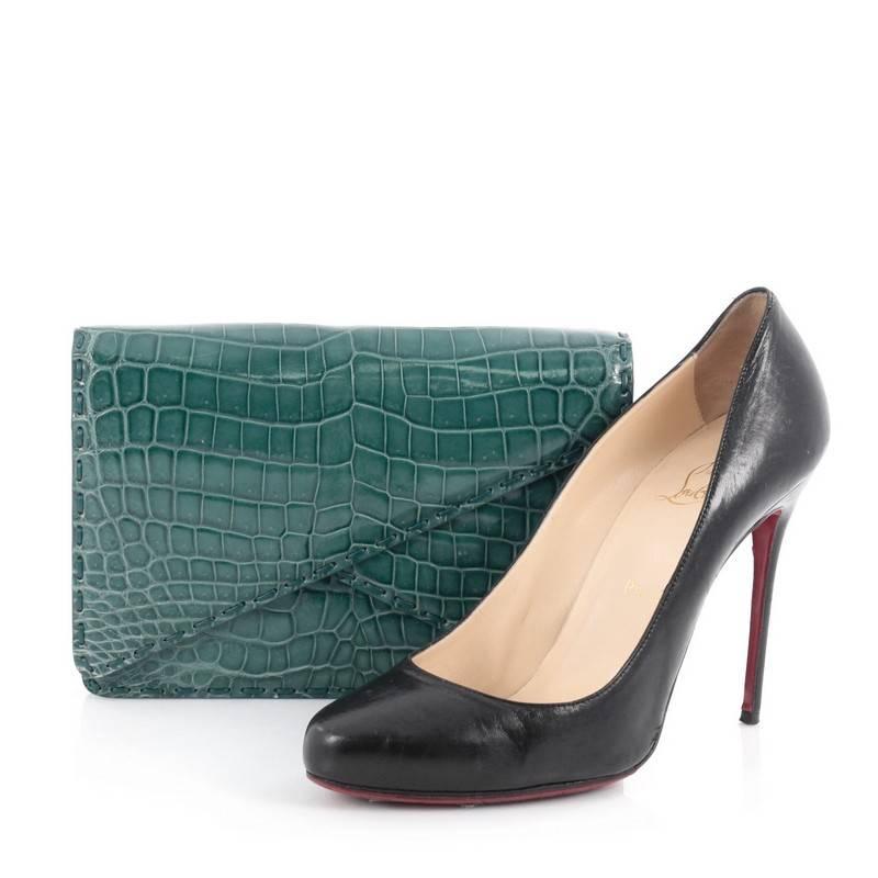 This authentic Bottega Veneta Piano Crisscross Clutch Crocodile Small presented in the brand's 2015 Collection is a luxurious and understated clutch synonymous to the brand's aesthetic. Crafted from genuine teal crocodile skin, this stylish clutch