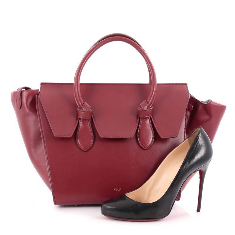 This authentic Celine Tie Knot Tote Smooth Leather Mini presented in the brand's Fall/Winter 2014 Collection is an absolute must-have for serious fashionistas. Crafted from red smooth leather, this boxy, chic tote features dual-rolled leather