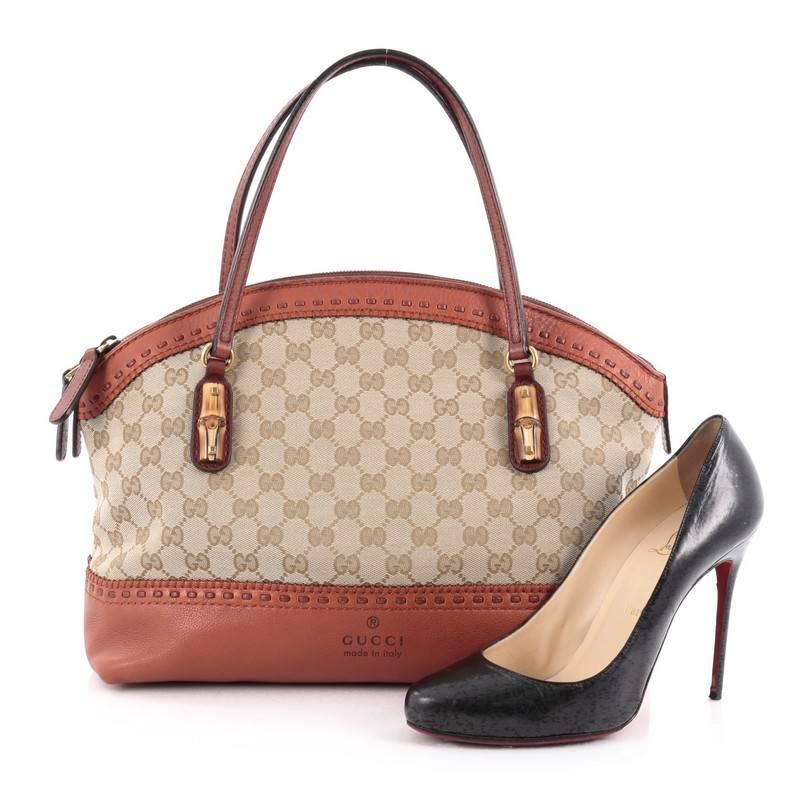This authentic Gucci Laidback Crafty Handle Bag GG Canvas Medium is a reinterpretation of the brand's rich heritage with modern, yet classic flair. Crafted from beige GG canvas with burnt orange leather trims, this luxurious tote features dual-flat