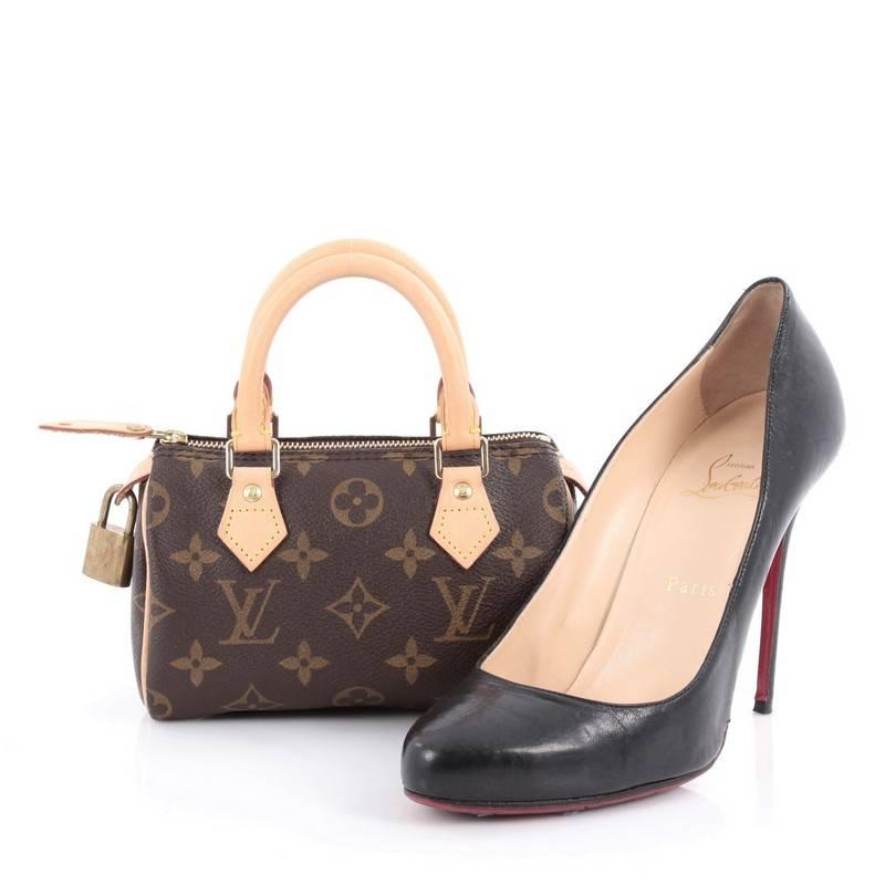 This authentic Louis Vuitton Speedy Mini HL Handbag Monogram Canvas is a lovable miniature speedy that is sure to grab everyone's attention. Crafted in brown monogram coated canvas, this baby-sized handle bag features vachetta leather handles and