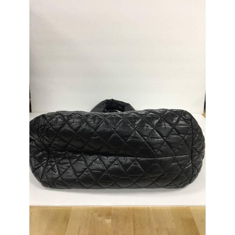 This authentic Chanel Coco Cocoon Bowling Bag Quilted Nylon is a highly sought after piece from Lagerfeld's fun and chic Coco Cocoon line. Crafted from puffy black quilted nylon, this lightweight, stylish bowler bag features dual-rolled nylon