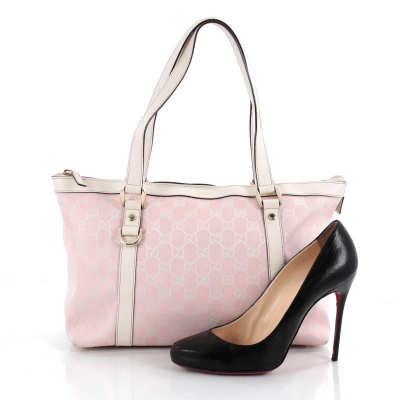 This authentic Gucci Abbey Tote GG Canvas Medium is ideal for everyday use. Constructed in pink GG canvas, this simple tote features dual flat leather handles, white leather trims, protective base studs and polished gold-tone hardware accents. Its