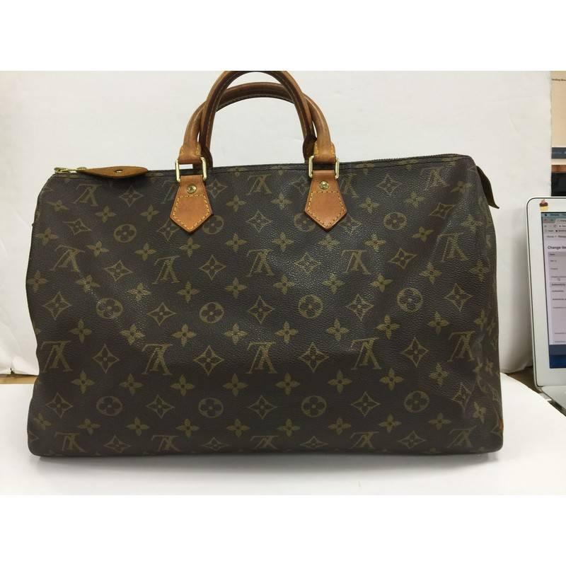 This authentic Louis Vuitton Speedy Handbag Monogram Canvas 40 is the largest of the speedy collection and a classic must-have. Constructed with the brand's iconic brown monogram coated canvas with vachetta leather trims, this rounded bag features