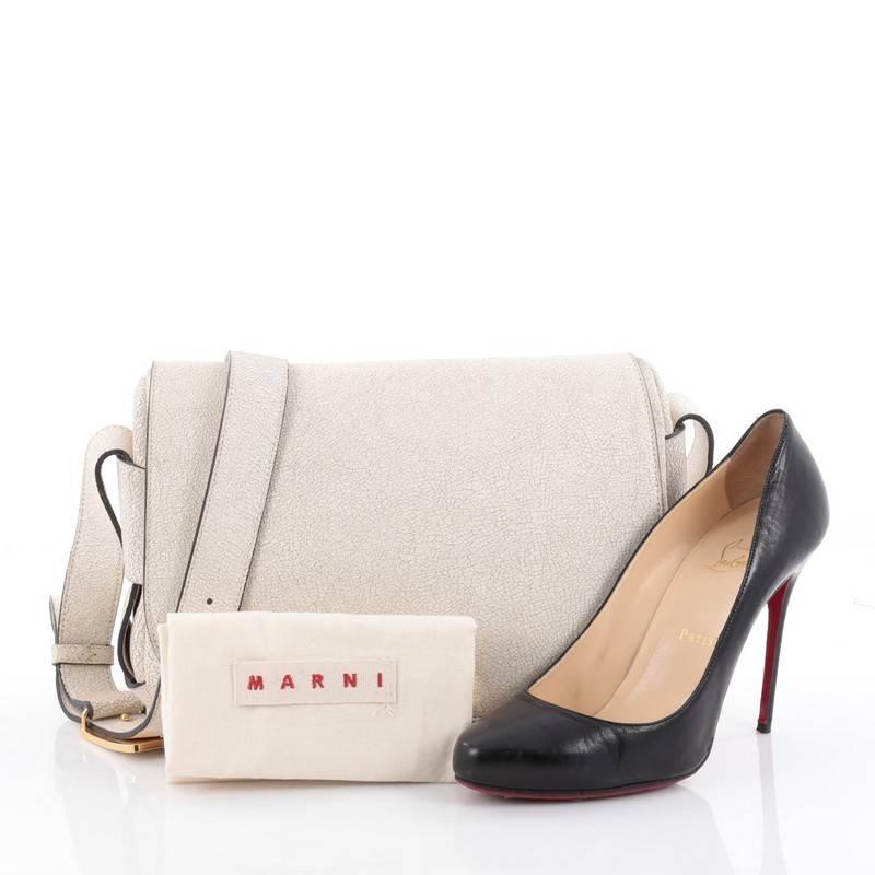 This authentic Marni Saddle Bag Leather Large is characterized by convenience and finished with a luxurious design. Crafted from beige leather, this stylish saddle features adjustable crossbody strap, exterior back zip pocket, and gold-tone hardware