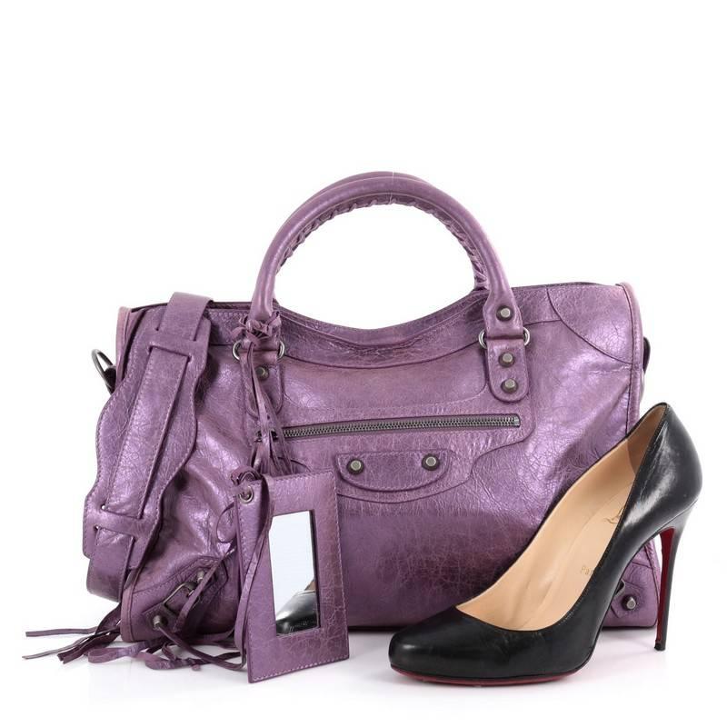 This authentic Balenciaga City Classic Studs Handbag Leather Medium is for the on-the-go fashionista. Constructed in purple metallic leather, this popular bag features dual braided woven handle straps, front zip pocket, iconic Balenciaga classic