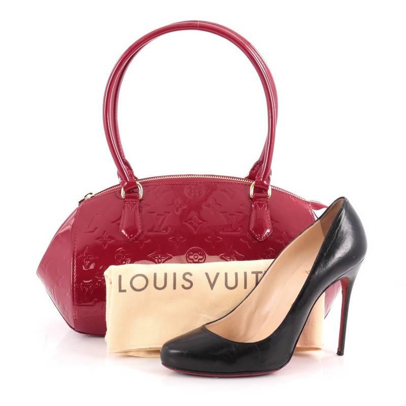 This authentic Louis Vuitton Sherwood Handbag Monogram Vernis PM is a uniquely shaped bag that showcase a modern take to Louis Vuitton's classic design. Crafted from red monogram vernis, this structured dome bag features dual-rolled leather handles