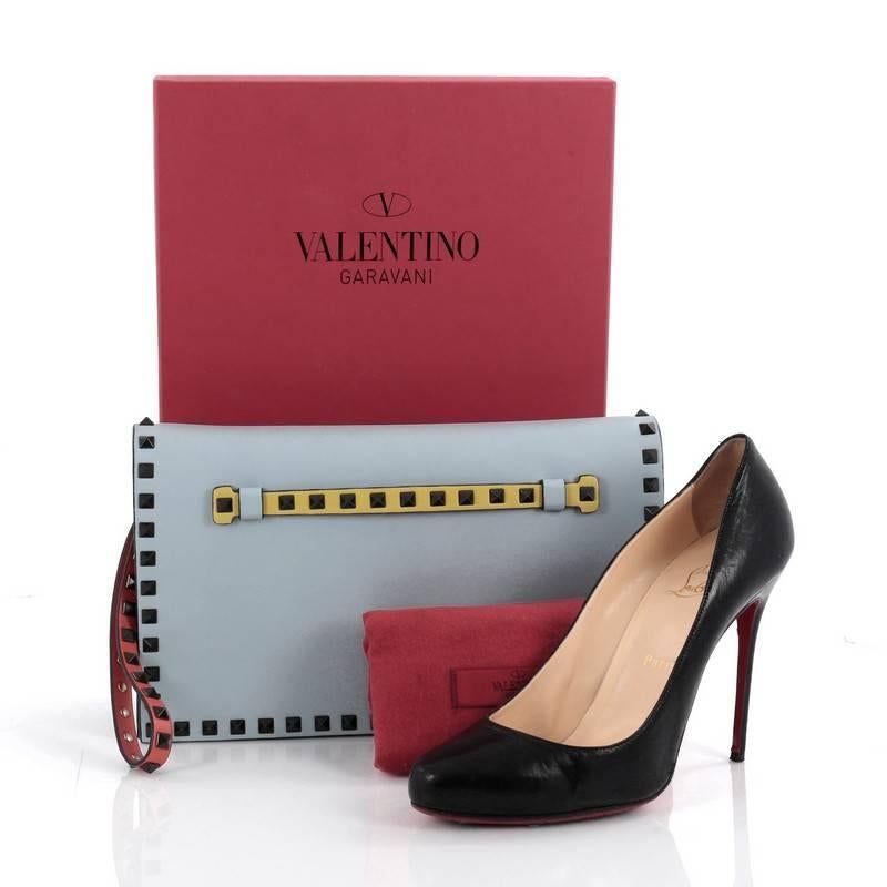 This authentic Valentino Rockstud Flap Clutch Leather is a chic yet functional accessory perfect for on-the-go moments. Crafted from blue leather, this trendy clutch features a leather hand sling, back studded hand strap, polished gunmetal Valentino