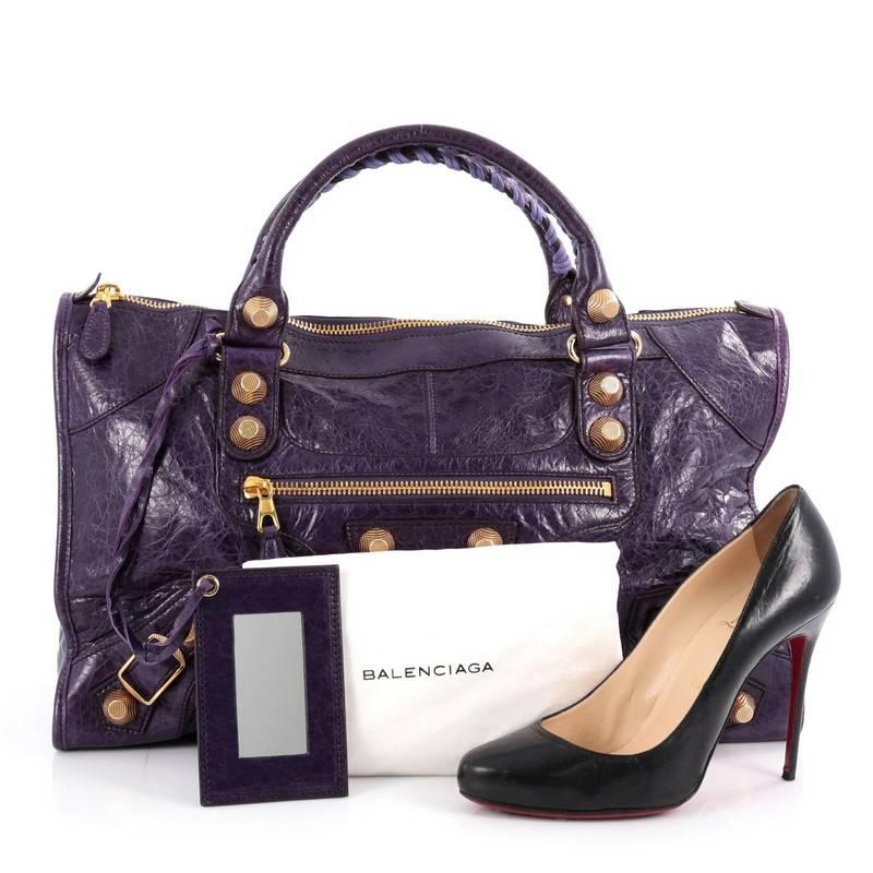 This authentic Balenciaga Work Giant Studs Handbag Leather is for the on-the-go fashionista. Constructed in purple leather, this popular bag features braided woven handles, long fringe details, front zipped pocket, buckle details, iconic Balenciaga